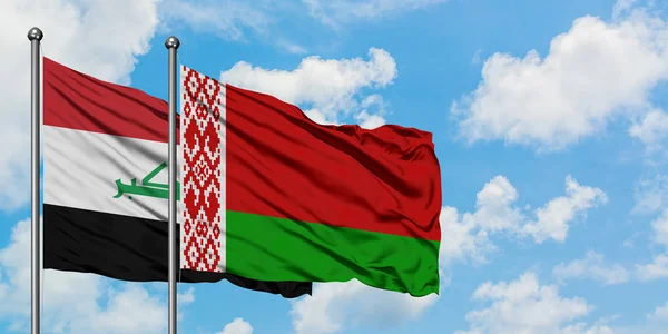 Iraq e Bielorussia sventolano bandiera nel vento contro bianco cielo blu nuvoloso insieme. Concetto di diplomazia, relazioni internazionali . — Foto Stock
