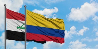 Irak ve Kolombiya bayrağı birlikte beyaz bulutlu mavi gökyüzüne karşı rüzgarsal sallayarak. Diplomasi kavramı, uluslararası ilişkiler.