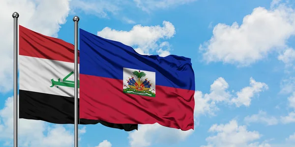 Bandera de Irak y Haití ondeando en el viento contra el cielo azul nublado blanco juntos. Concepto diplomático, relaciones internacionales . — Foto de Stock