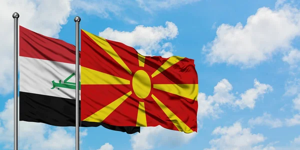Bandera de Irak y Macedonia ondeando en el viento contra el cielo azul nublado blanco juntos. Concepto diplomático, relaciones internacionales . — Foto de Stock