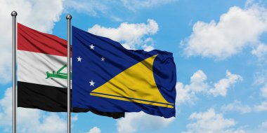 Irak ve Tokelau bayrağı birlikte beyaz bulutlu mavi gökyüzüne karşı rüzgarsal sallayarak. Diplomasi kavramı, uluslararası ilişkiler.