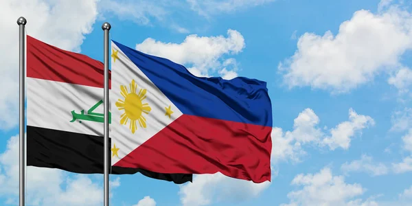 Bandera de Irak y Filipinas ondeando en el viento contra el cielo azul nublado blanco juntos. Concepto diplomático, relaciones internacionales . — Foto de Stock