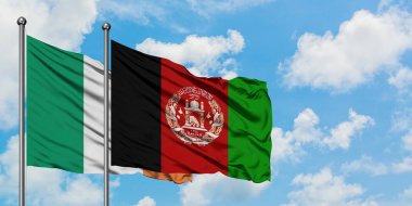 İrlanda ve Afganistan bayrağı birlikte beyaz bulutlu mavi gökyüzüne karşı rüzgarda sallayarak. Diplomasi kavramı, uluslararası ilişkiler.