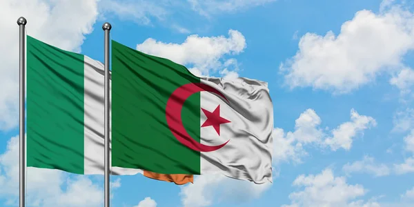 爱尔兰和阿尔及利亚国旗在风中飘扬，白云蓝天相聚。外交概念、国际关系. — 图库照片