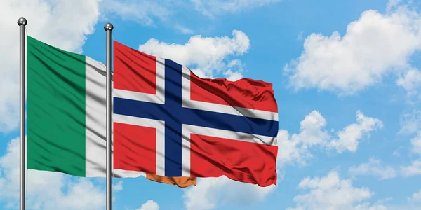 Bandera de Irlanda y Bouvet Islands ondeando en el viento contra el cielo azul nublado blanco juntos. Concepto diplomático, relaciones internacionales . — Foto de Stock