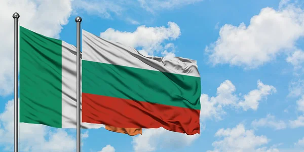 Bandera de Irlanda y Bulgaria ondeando en el viento contra el cielo azul nublado blanco juntos. Concepto diplomático, relaciones internacionales . — Foto de Stock