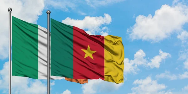 Bandera de Irlanda y Camerún ondeando en el viento contra el cielo azul nublado blanco juntos. Concepto diplomático, relaciones internacionales . — Foto de Stock