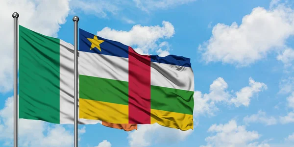Bandera de Irlanda y República Centroafricana ondeando en el viento contra el cielo azul nublado blanco juntos. Concepto diplomático, relaciones internacionales . — Foto de Stock