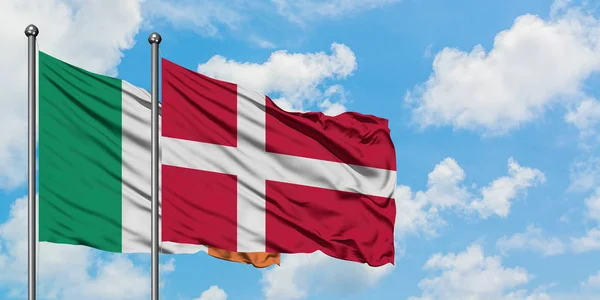 Bandera de Irlanda y Dinamarca ondeando en el viento contra el cielo azul nublado blanco juntos. Concepto diplomático, relaciones internacionales . — Foto de Stock