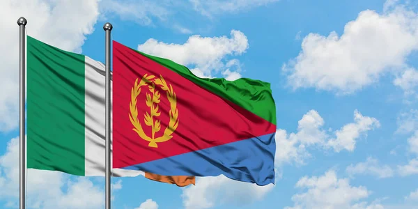 Bandera de Irlanda y Eritrea ondeando en el viento contra el cielo azul nublado blanco juntos. Concepto diplomático, relaciones internacionales . — Foto de Stock