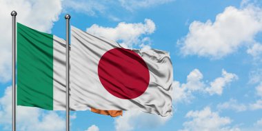 İrlanda ve Japonya bayrağı birlikte beyaz bulutlu mavi gökyüzüne karşı rüzgarda sallayarak. Diplomasi kavramı, uluslararası ilişkiler.