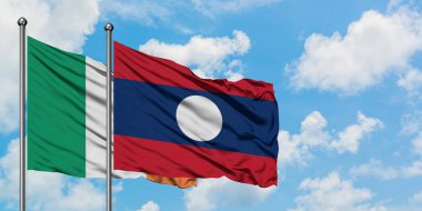 İrlanda ve Laos bayrağı birlikte beyaz bulutlu mavi gökyüzüne karşı rüzgarda sallayarak. Diplomasi kavramı, uluslararası ilişkiler.