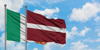 İrlanda ve Letonya bayrağı birlikte beyaz bulutlu mavi gökyüzüne karşı rüzgarda sallayarak. Diplomasi kavramı, uluslararası ilişkiler.