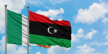 İrlanda ve Libya bayrağı birlikte beyaz bulutlu mavi gökyüzüne karşı rüzgarda sallayarak. Diplomasi kavramı, uluslararası ilişkiler.