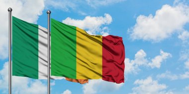 İrlanda ve Mali bayrağı birlikte beyaz bulutlu mavi gökyüzüne karşı rüzgarda sallayarak. Diplomasi kavramı, uluslararası ilişkiler.