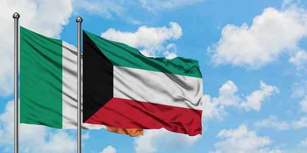 Bandera de Irlanda y Kuwait ondeando en el viento contra el cielo azul nublado blanco juntos. Concepto diplomático, relaciones internacionales . —  Fotos de Stock