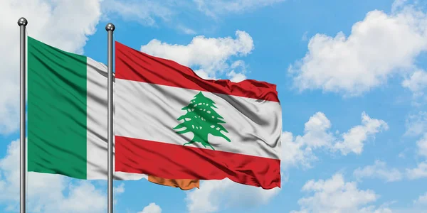 Bandera de Irlanda y Líbano ondeando en el viento contra el cielo azul nublado blanco juntos. Concepto diplomático, relaciones internacionales . — Foto de Stock