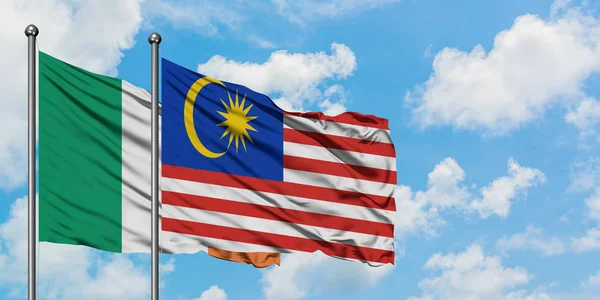 爱尔兰和马来西亚国旗在风中飘扬，白云蓝天相聚。外交概念、国际关系. — 图库照片