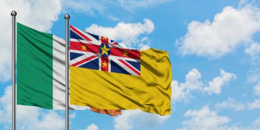 İrlanda ve Niue bayrağı birlikte beyaz bulutlu mavi gökyüzüne karşı rüzgarda sallayarak. Diplomasi kavramı, uluslararası ilişkiler.