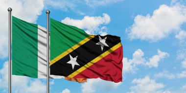 İrlanda ve Saint Kitts ve Nevis bayrağı birlikte beyaz bulutlu mavi gökyüzüne karşı rüzgarda sallayarak. Diplomasi kavramı, uluslararası ilişkiler.