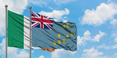 İrlanda ve Tuvalu bayrağı birlikte beyaz bulutlu mavi gökyüzüne karşı rüzgarda sallayarak. Diplomasi kavramı, uluslararası ilişkiler.