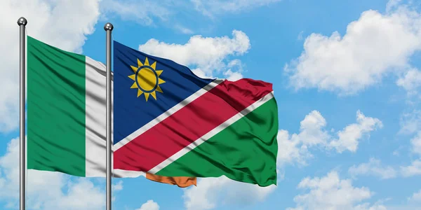 Ierland en Namibië vlag zwaaien in de wind tegen witte bewolkte blauwe hemel samen. Diplomatie concept, internationale betrekkingen. — Stockfoto