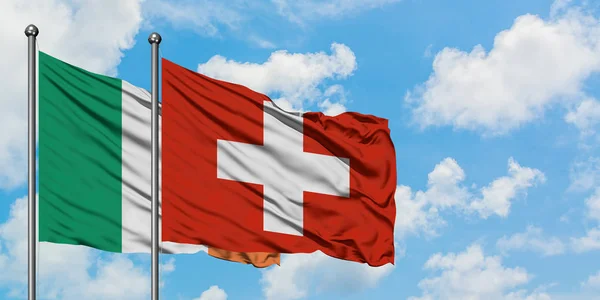 Флаг Ирландии и Швейцарии, размахивающий на ветру против белого облачного голубого неба. Концепция дипломатии, международные отношения . — стоковое фото