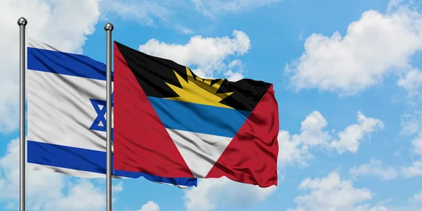 İsrail ve Antigua ve Barbuda bayrağı birlikte beyaz bulutlu mavi gökyüzüne karşı rüzgarda sallayarak. Diplomasi kavramı, uluslararası ilişkiler. — Stok fotoğraf