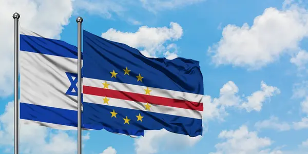 Bandera de Israel y Cabo Verde ondeando en el viento contra el cielo azul nublado blanco juntos. Concepto diplomático, relaciones internacionales . — Foto de Stock