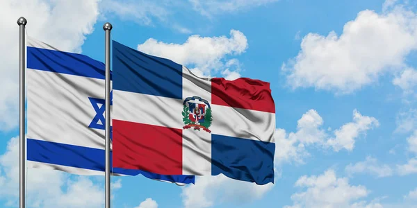 Bandera de Israel y República Dominicana ondeando en el viento contra el cielo azul nublado blanco juntos. Concepto diplomático, relaciones internacionales . — Foto de Stock