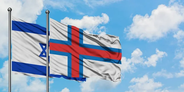 Bandera de Israel y las Islas Feroe ondeando en el viento contra el cielo azul nublado blanco juntos. Concepto diplomático, relaciones internacionales . —  Fotos de Stock