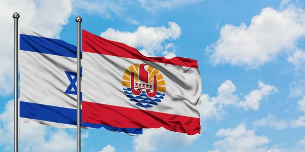 Ізраїль і Французька Полінезія прапор розмахуючи в вітру проти білого хмарного синього неба разом. Концепція дипломатії, міжнародні відносини. — стокове фото