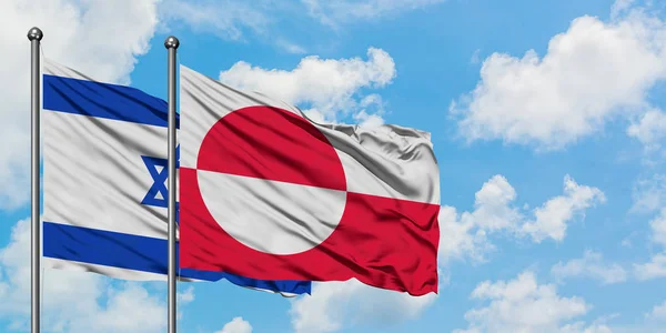 Drapeau d'Israël et du Groenland agitant dans le vent contre ciel bleu nuageux blanc ensemble. Concept de diplomatie, relations internationales . — Photo