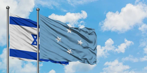 Bandera de Israel y Micronesia ondeando en el viento contra el cielo azul nublado blanco juntos. Concepto diplomático, relaciones internacionales . —  Fotos de Stock