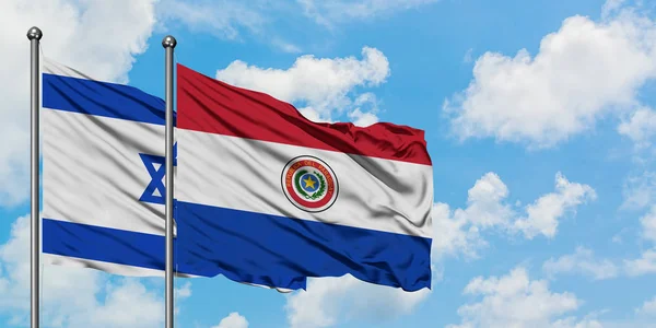 Israel and Paraguay flag waving in the wind against white cloudy blue sky together. Diplomacy concept, international relations. — Stock Photo, Image