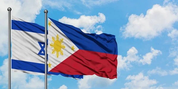 Bandera de Israel y Filipinas ondeando en el viento contra el cielo azul nublado blanco juntos. Concepto diplomático, relaciones internacionales . — Foto de Stock