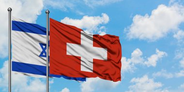 İsrail ve İsviçre bayrağı birlikte beyaz bulutlu mavi gökyüzüne karşı rüzgarsal sallayarak. Diplomasi kavramı, uluslararası ilişkiler.