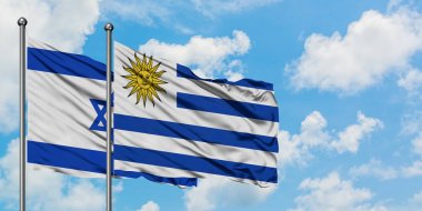 İsrail ve Uruguay bayrağı birlikte beyaz bulutlu mavi gökyüzüne karşı rüzgarsal sallayarak. Diplomasi kavramı, uluslararası ilişkiler.