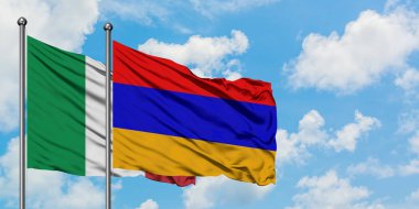 İtalya ve Ermenistan bayrağı birlikte beyaz bulutlu mavi gökyüzüne karşı rüzgarsal sallayarak. Diplomasi kavramı, uluslararası ilişkiler.