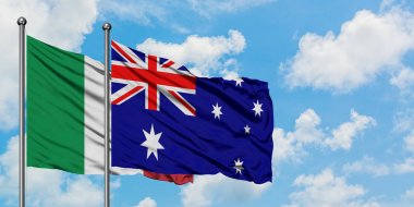 İtalya ve Avustralya bayrağı birlikte beyaz bulutlu mavi gökyüzüne karşı rüzgarda sallayarak. Diplomasi kavramı, uluslararası ilişkiler.