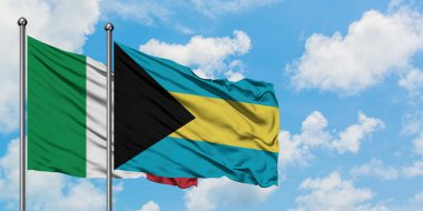 İtalya ve Bahamalar bayrağı birlikte beyaz bulutlu mavi gökyüzüne karşı rüzgarda sallayarak. Diplomasi kavramı, uluslararası ilişkiler.