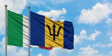 İtalya ve Barbados bayrağı birlikte beyaz bulutlu mavi gökyüzüne karşı rüzgarda sallayarak. Diplomasi kavramı, uluslararası ilişkiler.