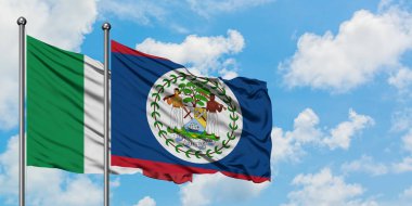 İtalya ve Belize bayrağı birlikte beyaz bulutlu mavi gökyüzüne karşı rüzgarda sallayarak. Diplomasi kavramı, uluslararası ilişkiler.