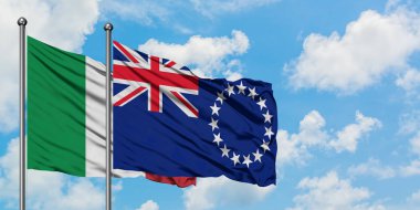 İtalya ve Cook Adaları bayrağı birlikte beyaz bulutlu mavi gökyüzüne karşı rüzgarda sallayarak. Diplomasi kavramı, uluslararası ilişkiler.