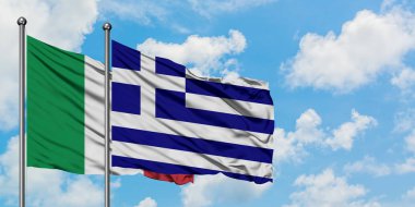 İtalya ve Yunanistan bayrağı birlikte beyaz bulutlu mavi gökyüzüne karşı rüzgarda sallayarak. Diplomasi kavramı, uluslararası ilişkiler.
