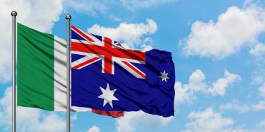 İtalya ve Heard Adası ve Mcdonald Adaları bayrağı birlikte beyaz bulutlu mavi gökyüzüne karşı rüzgarda sallayarak. Diplomasi kavramı, uluslararası ilişkiler.