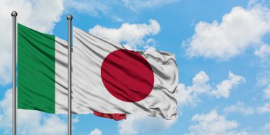 İtalya ve Japonya bayrağı birlikte beyaz bulutlu mavi gökyüzüne karşı rüzgarda sallayarak. Diplomasi kavramı, uluslararası ilişkiler.