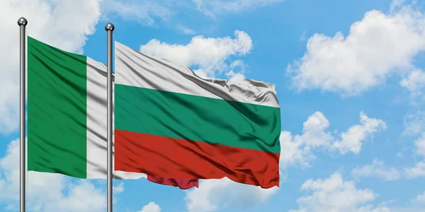 Bandera de Italia y Bulgaria ondeando en el viento contra el cielo azul nublado blanco juntos. Concepto diplomático, relaciones internacionales . — Foto de Stock