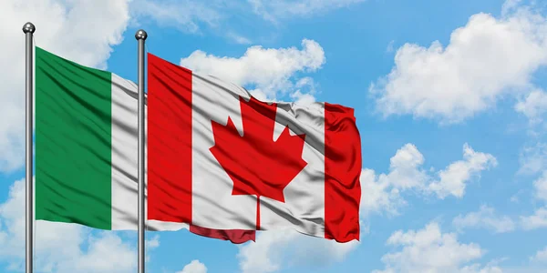 Bandera de Italia y Canadá ondeando en el viento contra el cielo azul nublado blanco juntos. Concepto diplomático, relaciones internacionales . — Foto de Stock