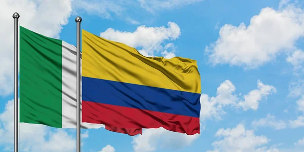 Bandera de Italia y Colombia ondeando en el viento contra el cielo azul nublado blanco juntos. Concepto diplomático, relaciones internacionales . — Foto de Stock